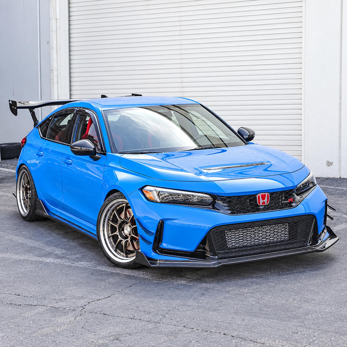 Carbon fiber aero kit with glossy finish, showing front air dam, side rocker extensions, and rear bumper skirts.