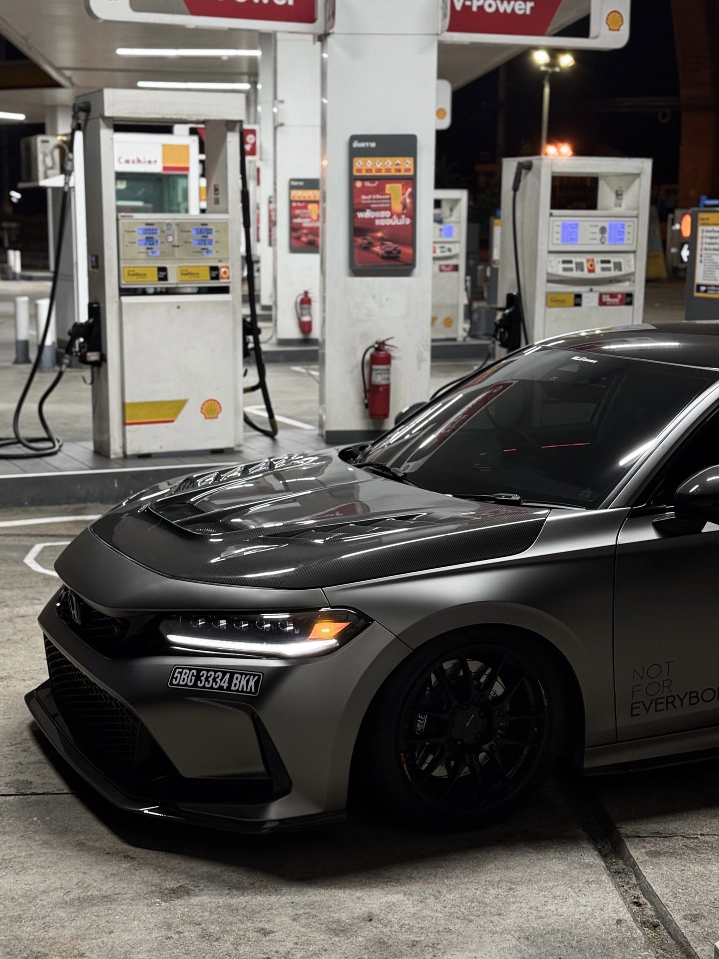 Aftermarket carbon fiber hood on 2023+ Honda Civic Type R, front three-quarter lifestyle photo