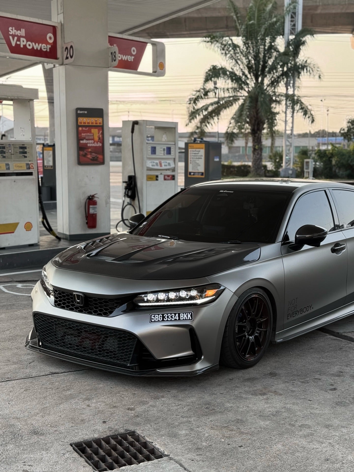 UMS carbon fiber hood V2 on silver Honda Civic Type R FL5 at gas station