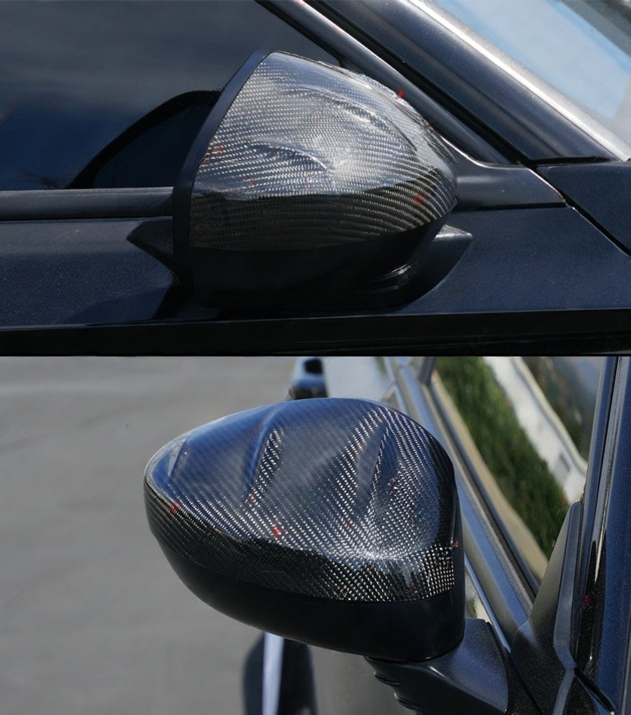 Three-quarter close-up of carbon fiber Acura Integra mirror caps on black side mirrors